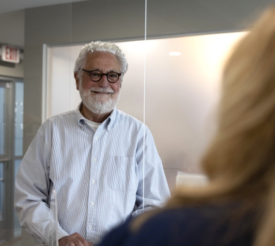 Smiling older man talking to dental team member