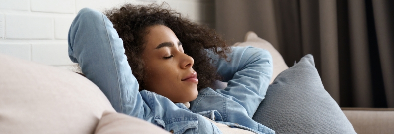 Woman relaxing with her eyes closed and her hands behind her head